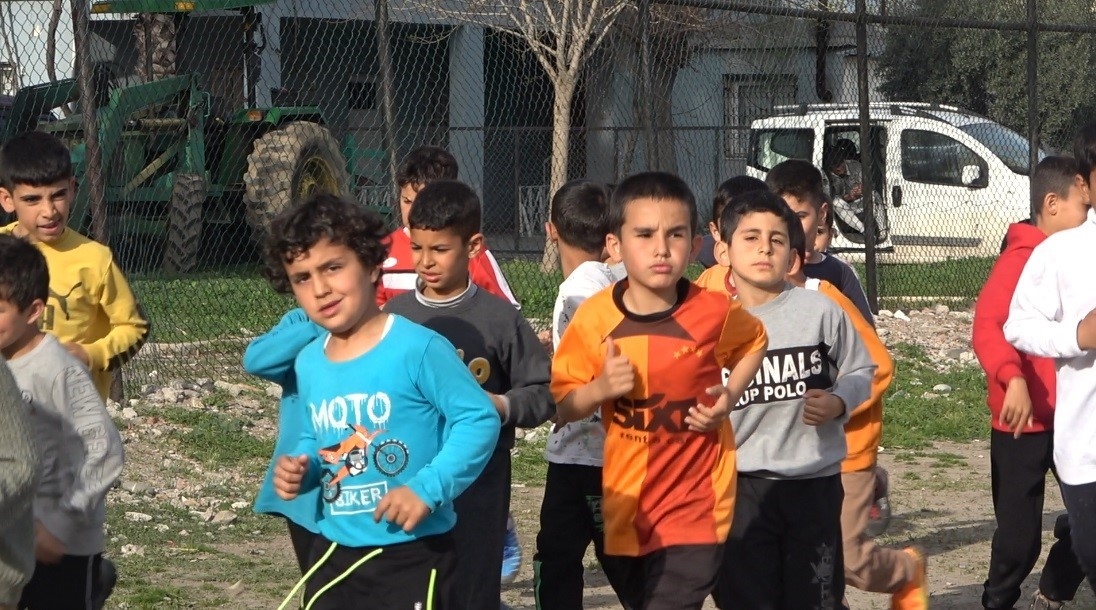 Futbol meraklısı depremzede çocuklar, toprak sahada tozu dumana katıyor