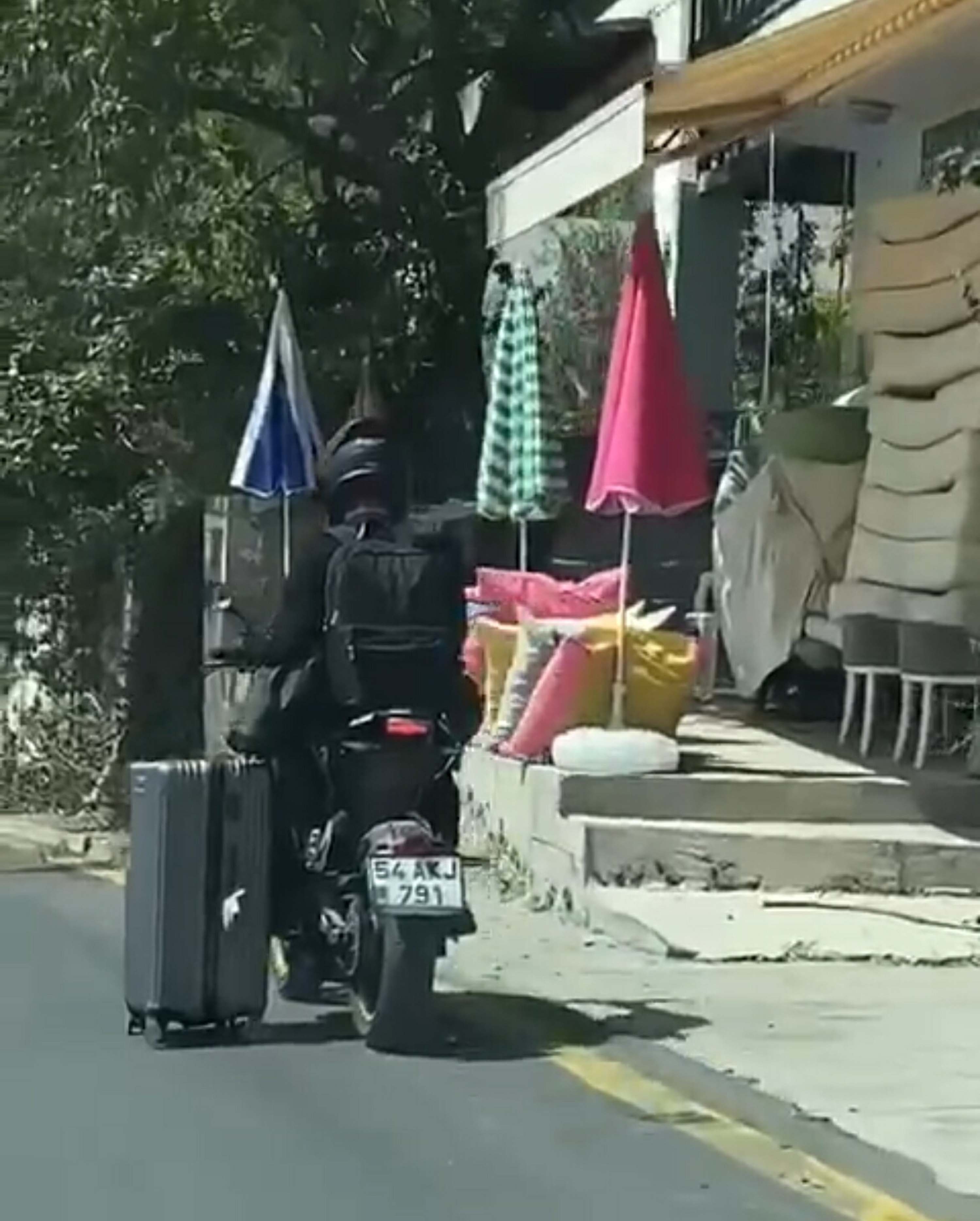 Motosikletlinin valiziyle tehlikeli yolculuğu