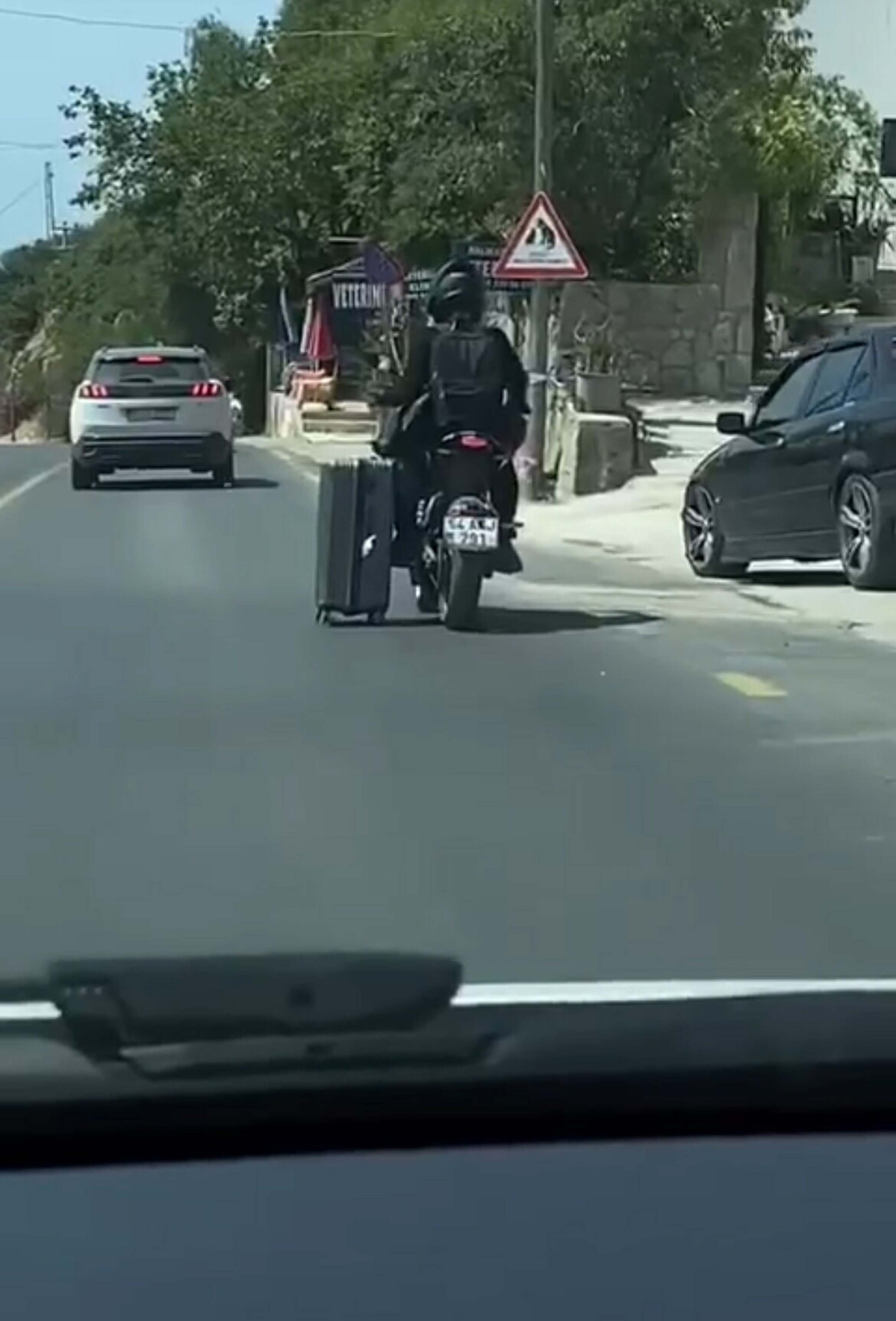 Motosikletlinin valiziyle tehlikeli yolculuğu