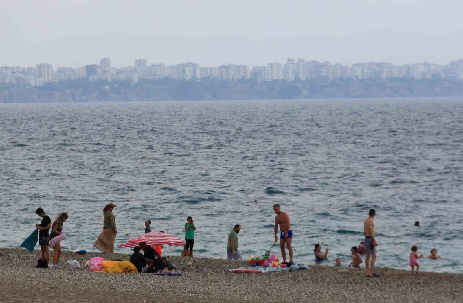 Konyaaltı'nda denizin keyfini çıkartan vatandaşlara yağış sürprizi