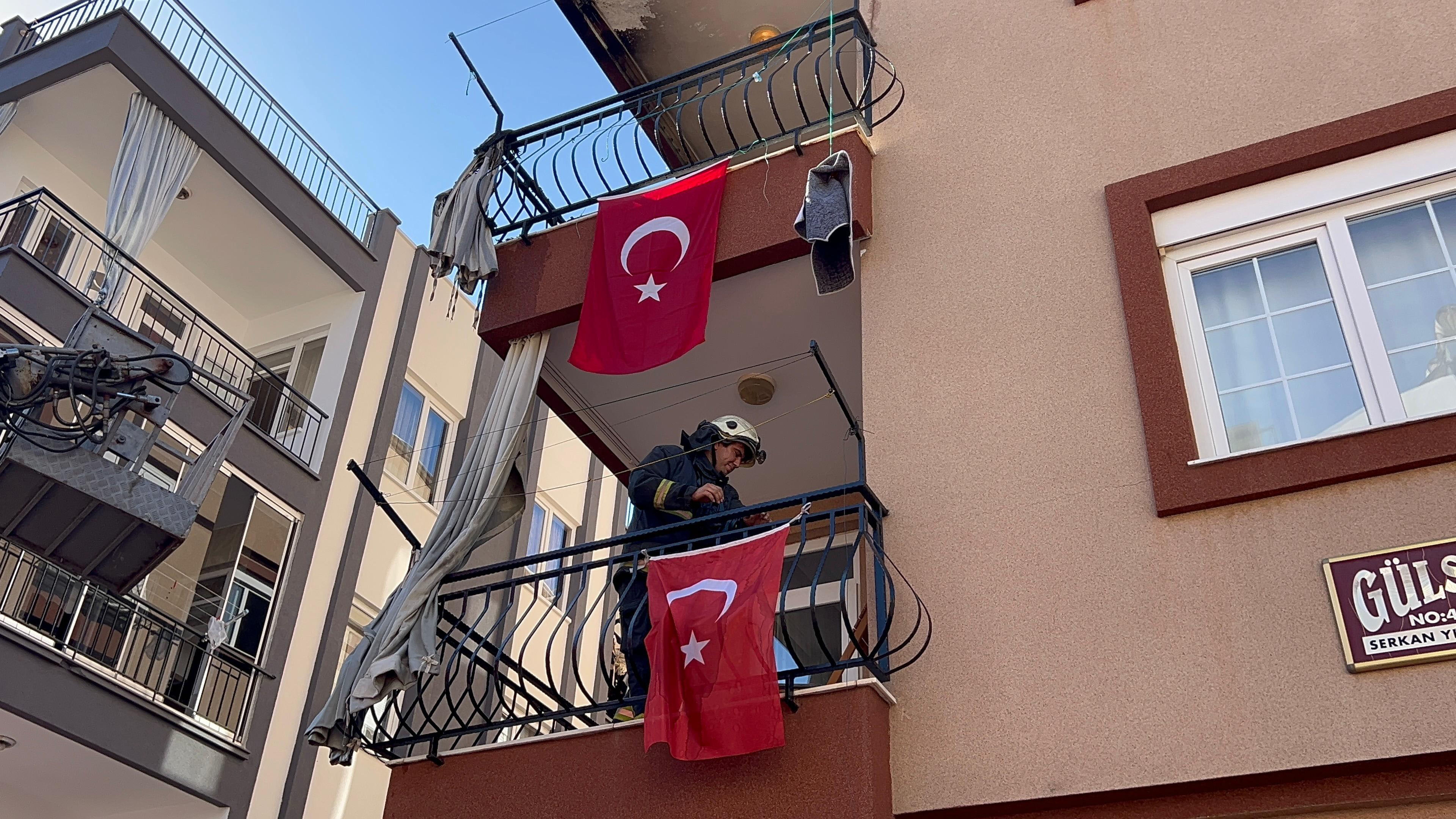 İtfaiye eri yangında zarar görmesini önlediği bayrakları düzeltti