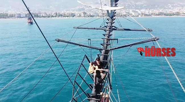 Teknenin tepesinde gitarla Alanya tanıtımı yaptı
