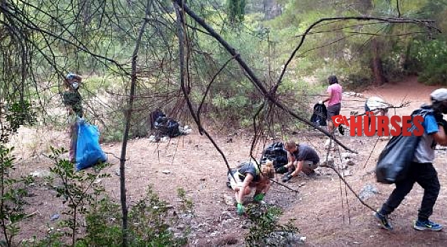 Kalkan gönüllüleri, orman yangını çıkarabilecek 300 torba çöp topladı