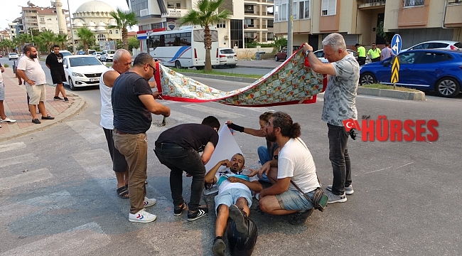 Kazada yaralanan motosiklet sürücüsünü çarşafla güneşten korumaya çalıştılar