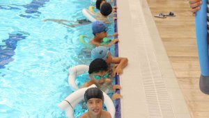 Elmalı'da çocuklar hem yüzme öğreniyor hem de serinliyor