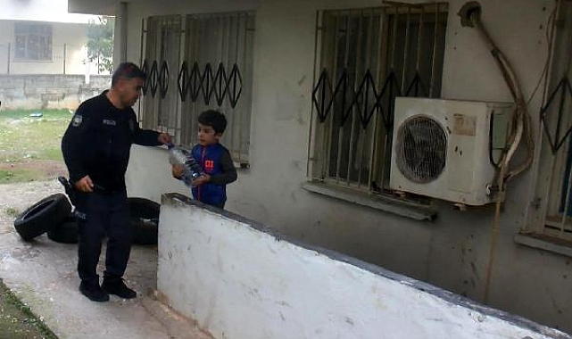 Küçük çocuk, yangın söndürme çalışması sırasında bidonla su taşıdı