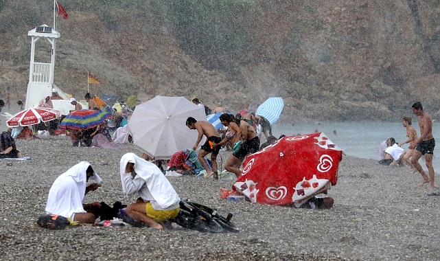 Antalya'da sıcaktan bunalanlar denizde yağmura yakalandı