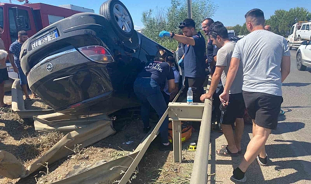 Takla atan araçta sıkıştı, telefonları elinden bırakmadı