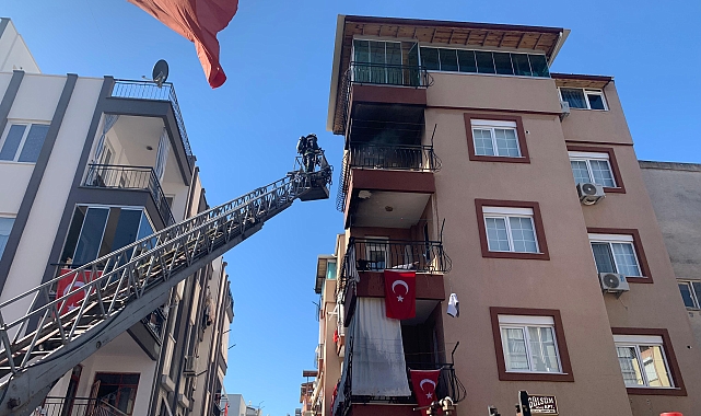 İtfaiye eri yangında zarar görmesini önlediği bayrakları düzeltti