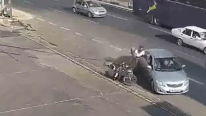 Kazada motosiklet sürücüsü çarpıştığı otomobilin kapısına tutunup sonra yere düştü