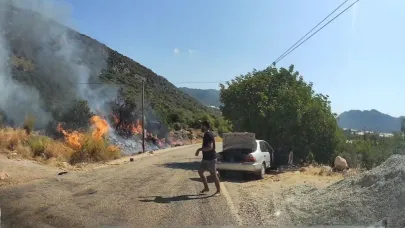 Yol kenarındaki yangını gören tatilci aile alevlere yangın tüpüyle müdahale etti