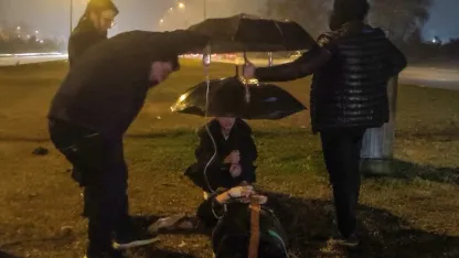 Kazada yaralanan kadın ıslanmasın diye şemsiye ile başında beklediler